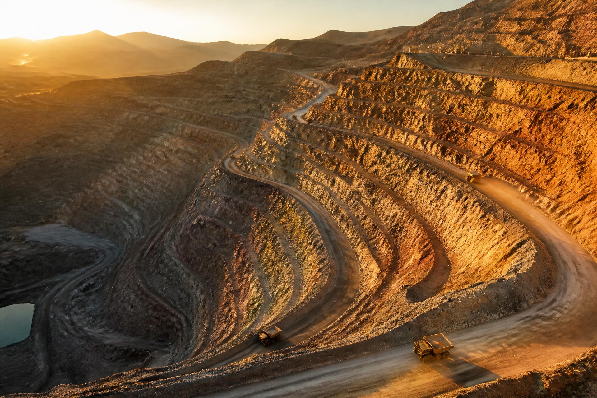 Aerial view of a vast open-pit mining operation at dusk